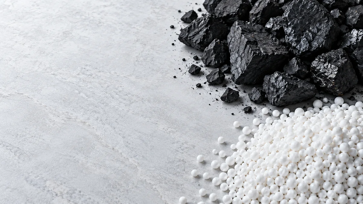 Fragmentos de carbón y gránulos blancos en una composición conceptual de materiales.